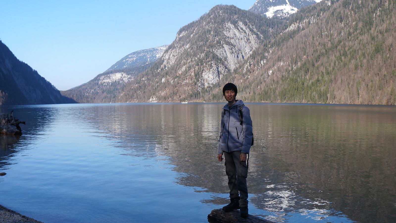 PhD candidate Wei Ji Leong stands by a lake in Königssee, Germany.