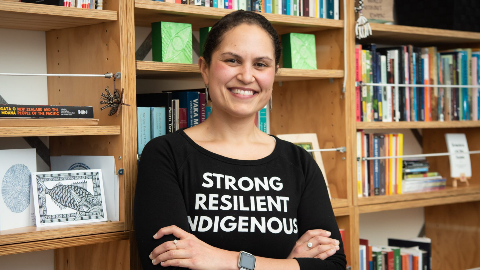 woman with black tshirt standing against books