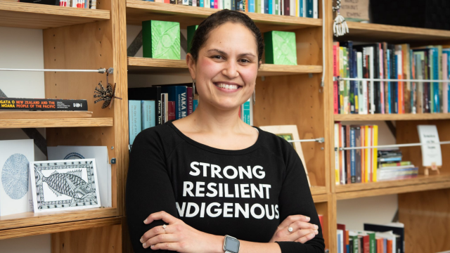woman with black tshirt standing against books