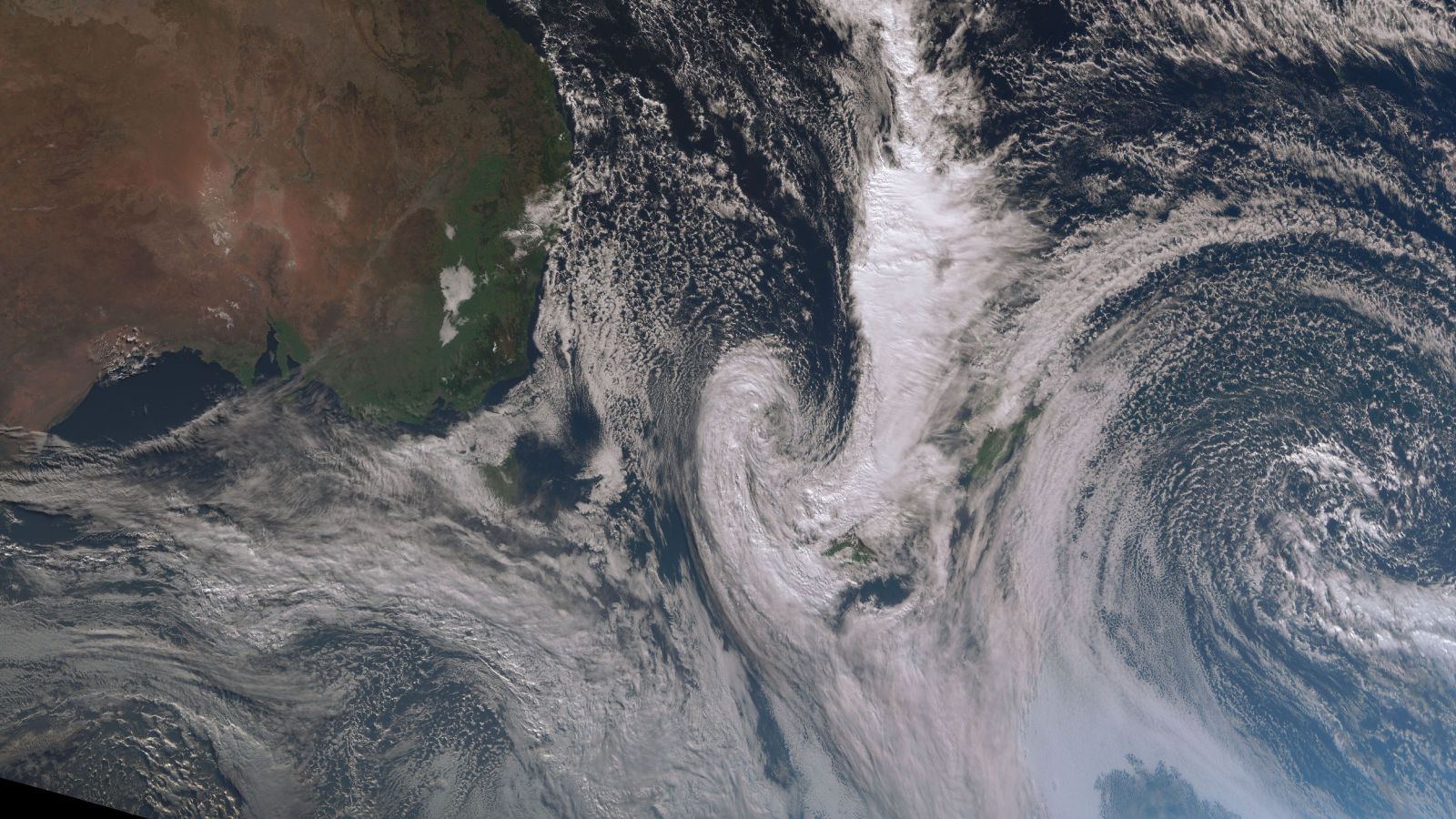 Satellite image of swirling white weather system over New Zealand