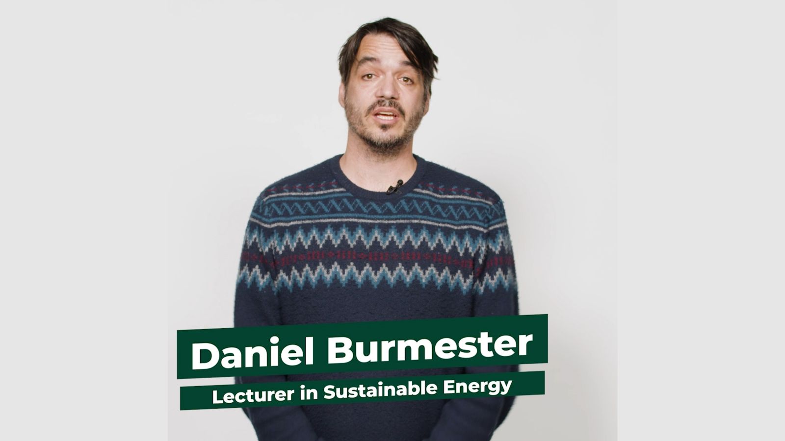 Lecturer Danical Burmester stands facing the camera against a white background