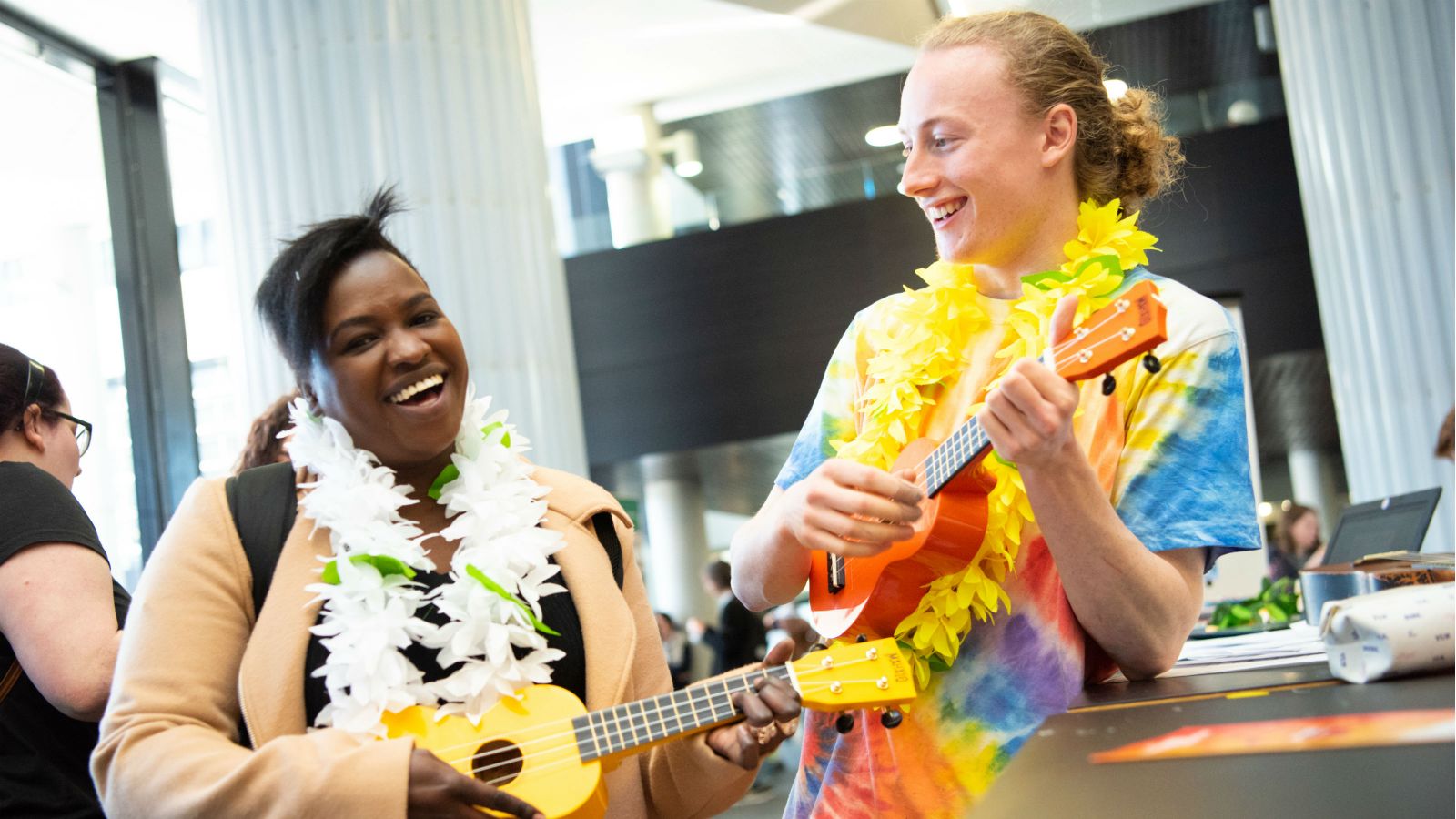 Photograph of two students playing ukuleles 