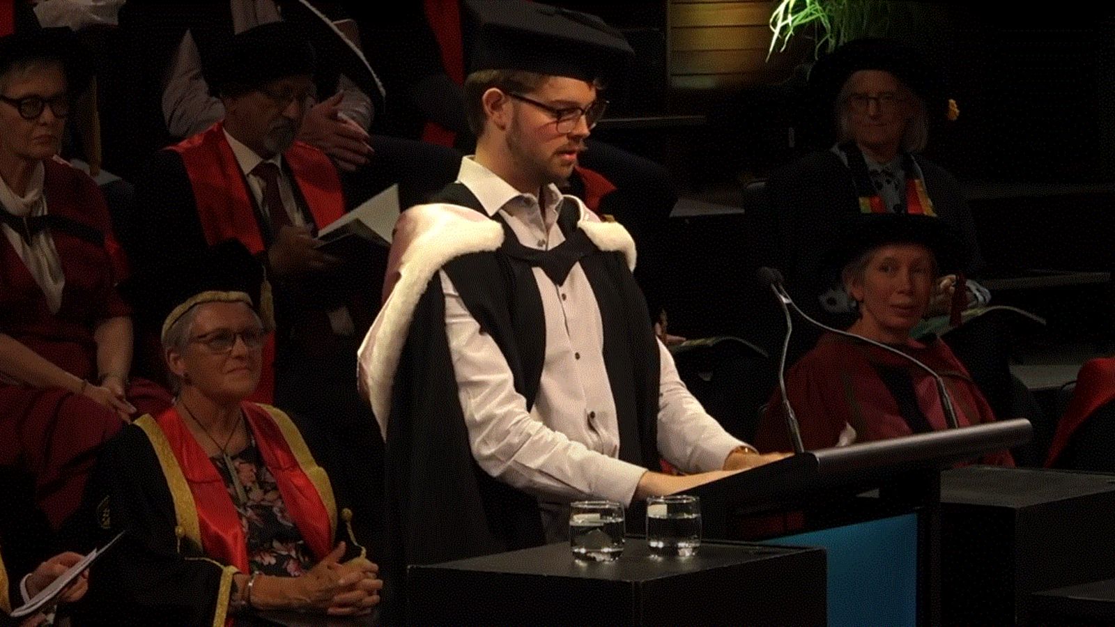 James Parrott, dressed in academic robes, speaking at the graduation ceremony.