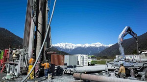 Big drilling machine with snowy cap mountains in the background alpine drilling project new phase