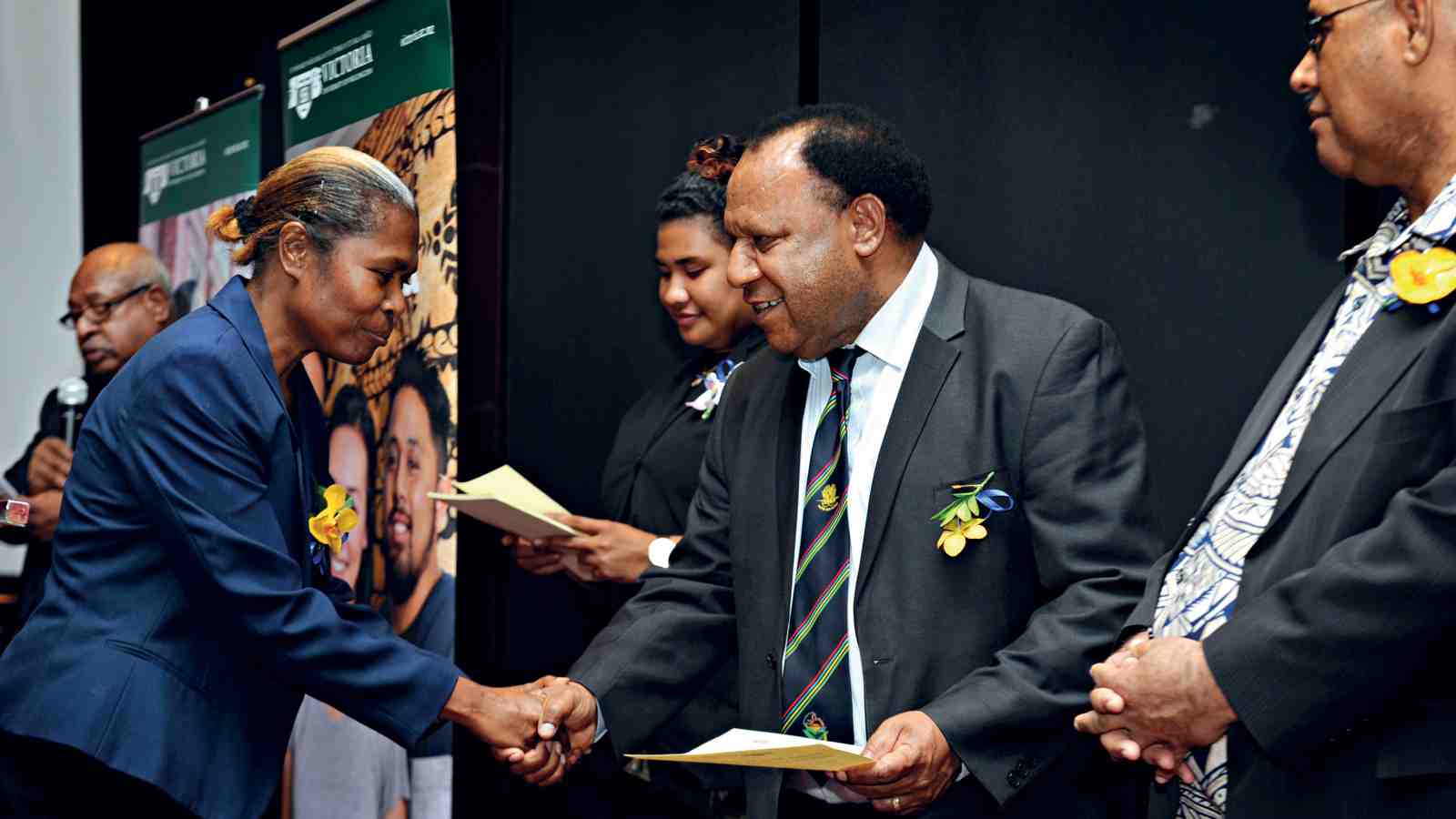 Judith Silau, human resources acting director, receives her certificate from Papua New Guinea's Minister for Foreign Affairs and Immigration Hon. Rimbink Pato