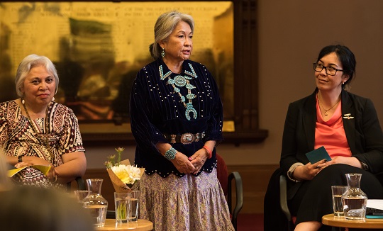 Luci stands and introduces herself while Winnie and Rawinia sit either side.