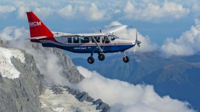 Image of a propeller driven aircraft over the mountains. 