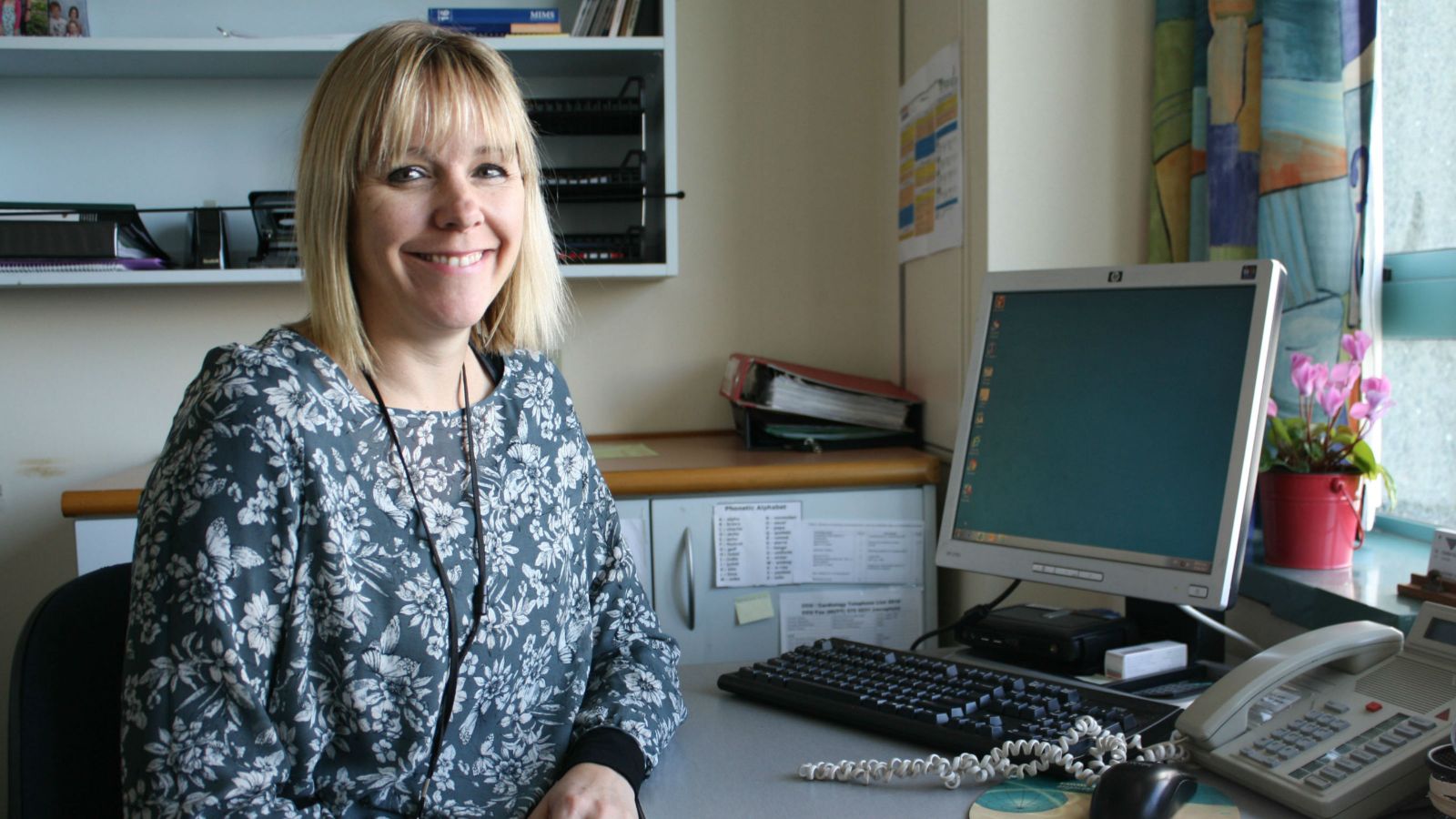 Jane Clarke posing for a photo at her desk.