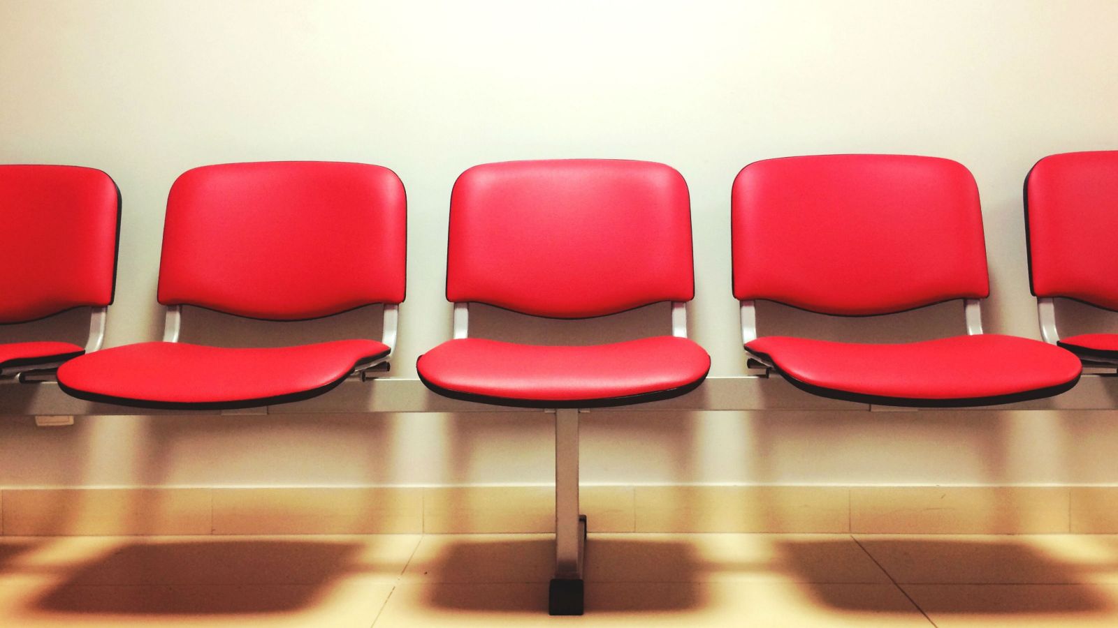 Red chairs in a doctor's waiting room.