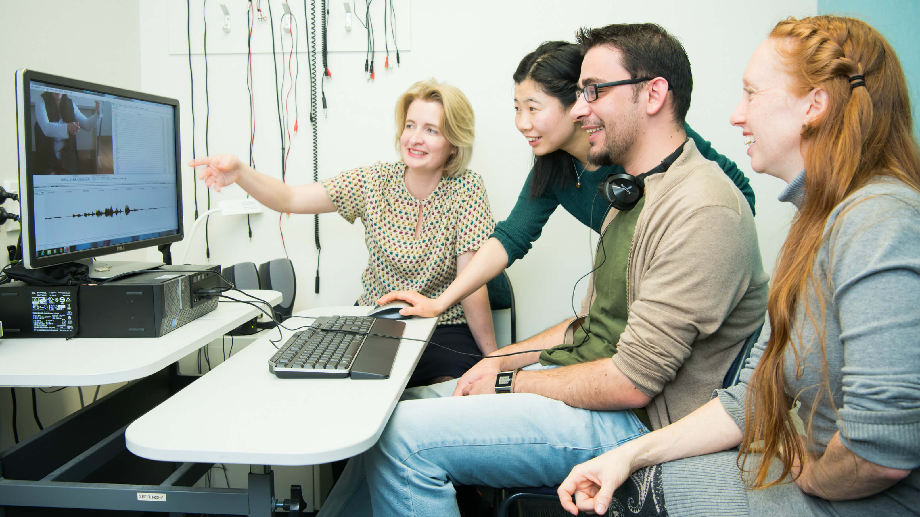Linguistics and Applied Language Studies students are sitting around a computer conducting a translation exercise.