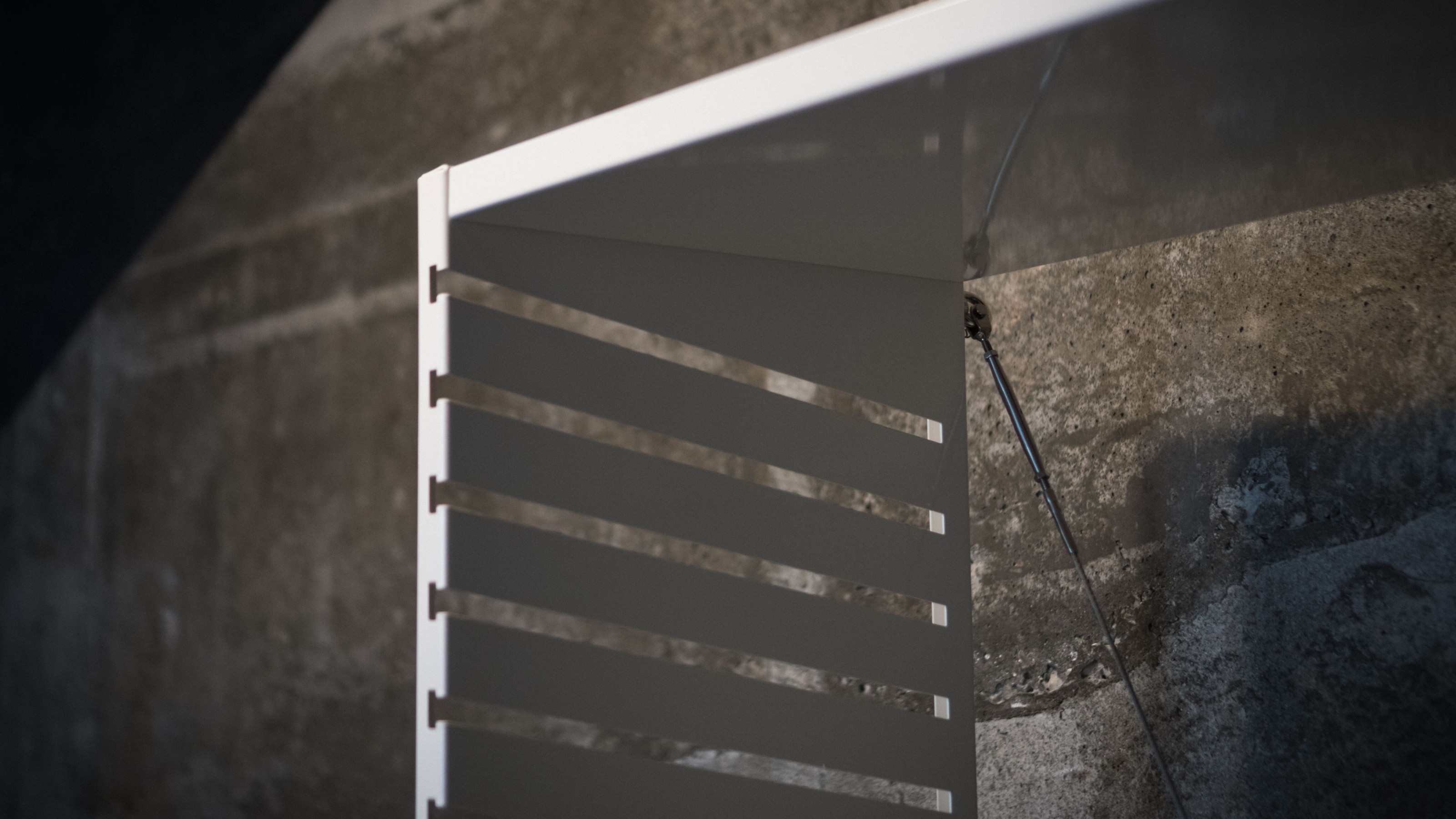 Close up of white shelf unit made of folded sheet of metal with slots to hold shelves