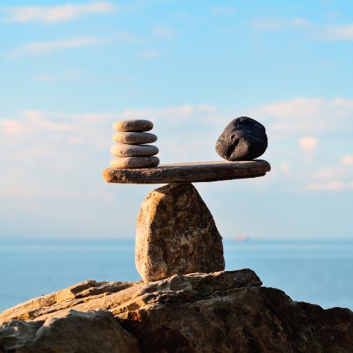 Pile of rocks balancing one on top of the other, with a view of the horizon in the background..