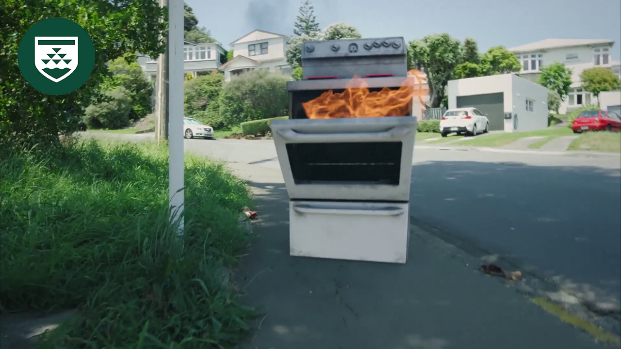 An image of a stove on fire on a sidewalk.
