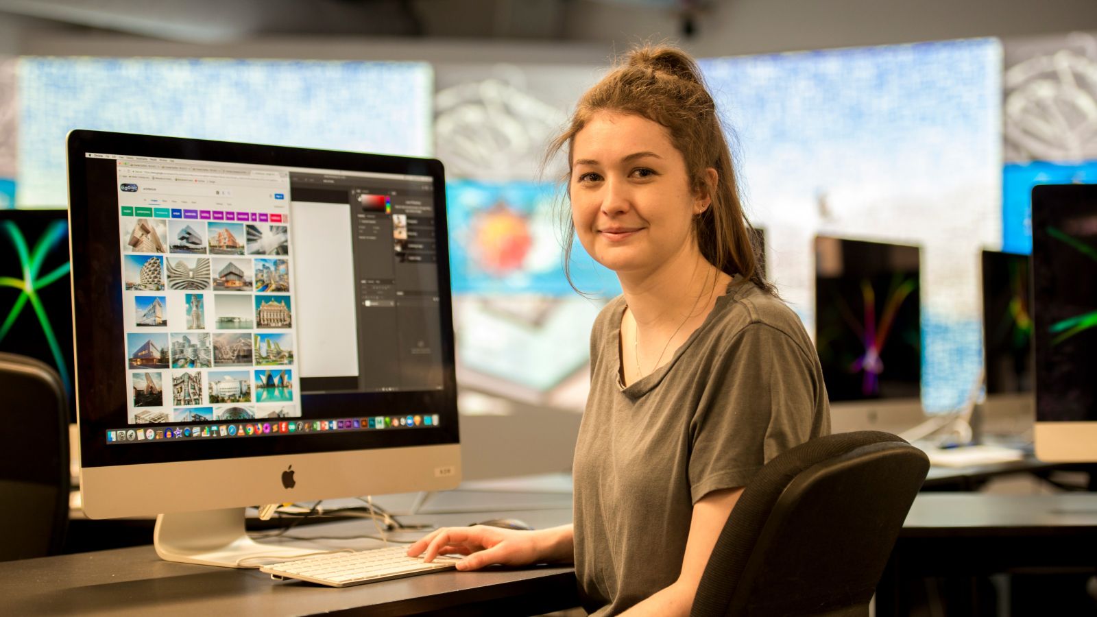 Sarah Buet Bachelor of Building Science student sitting at desk in front of iMac