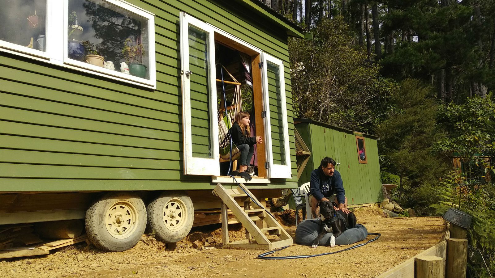 Daniel Burmester and his daughter, Charlee, sit outside their tiny house.  