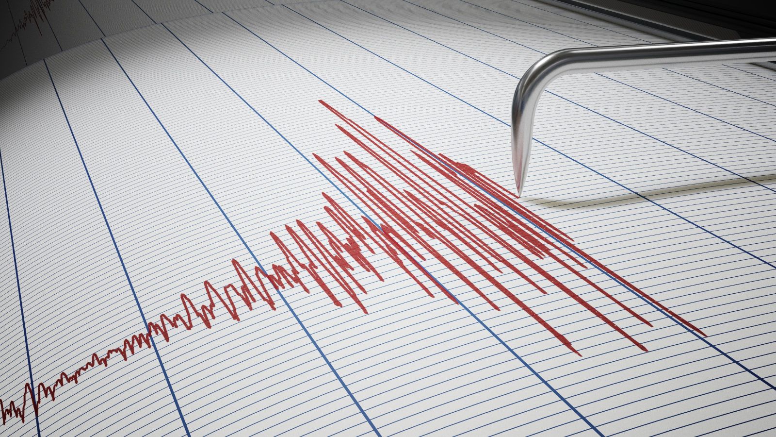 A seismograph needle and the red lines it is making recording an earthquake 