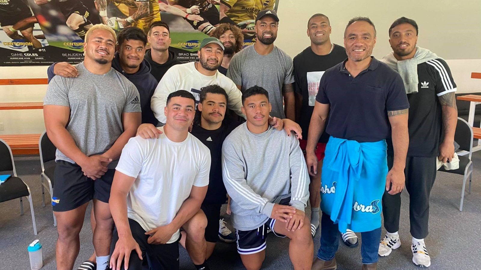 Men pose for a photo, front row kneeling in front of the back row