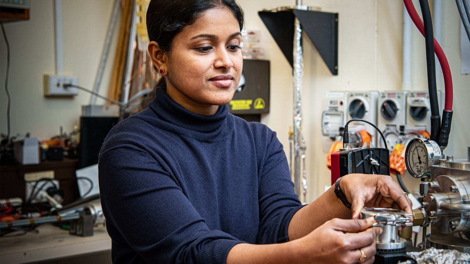 A female scientist testing superconductor wire in a laboratory.
