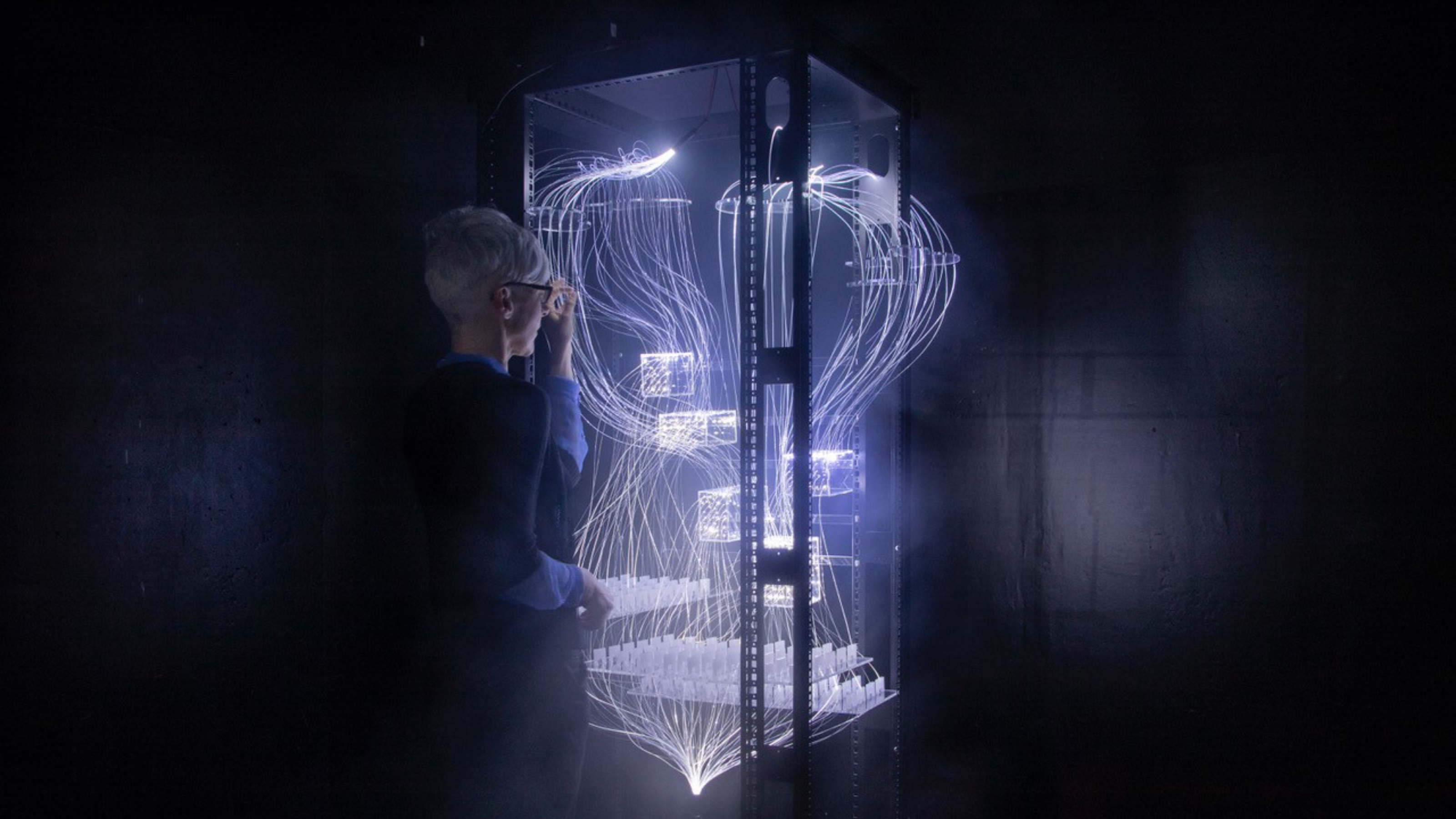 Woman looking at a structure with multiple illuminated cables