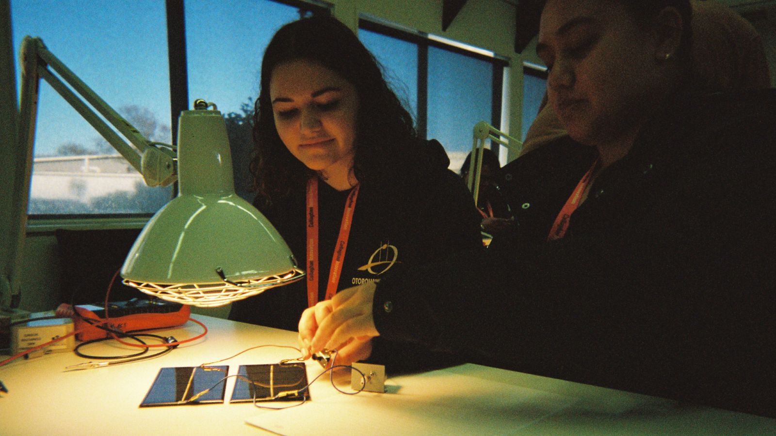 Group of secondary school students connecting circuits to solar panels. 