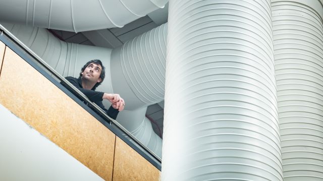 German stands on a balcony looking into the distance.