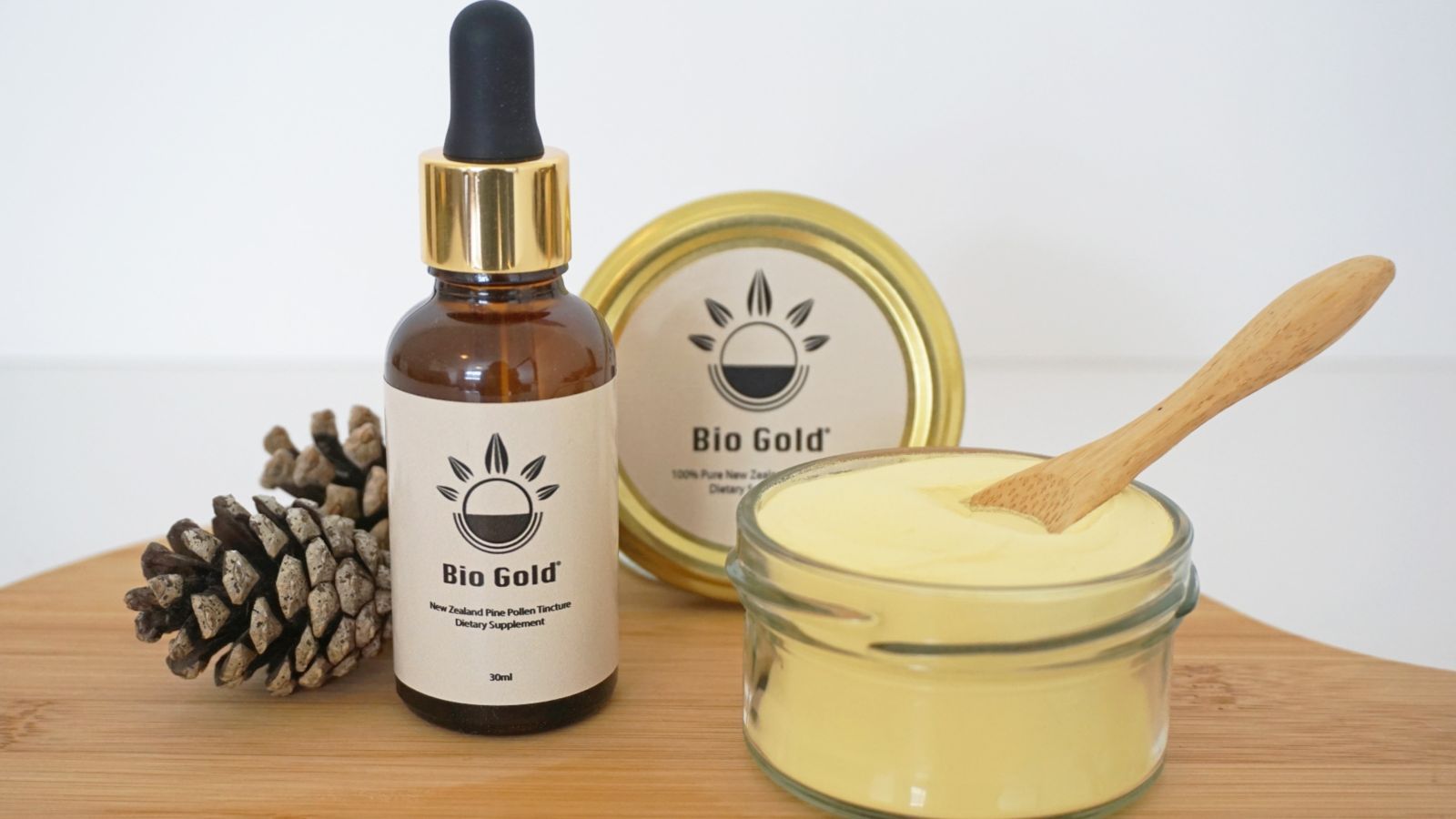 Bio Gold combo Promotional display of tincture jar, eyedropper bottle, and two pine cones
