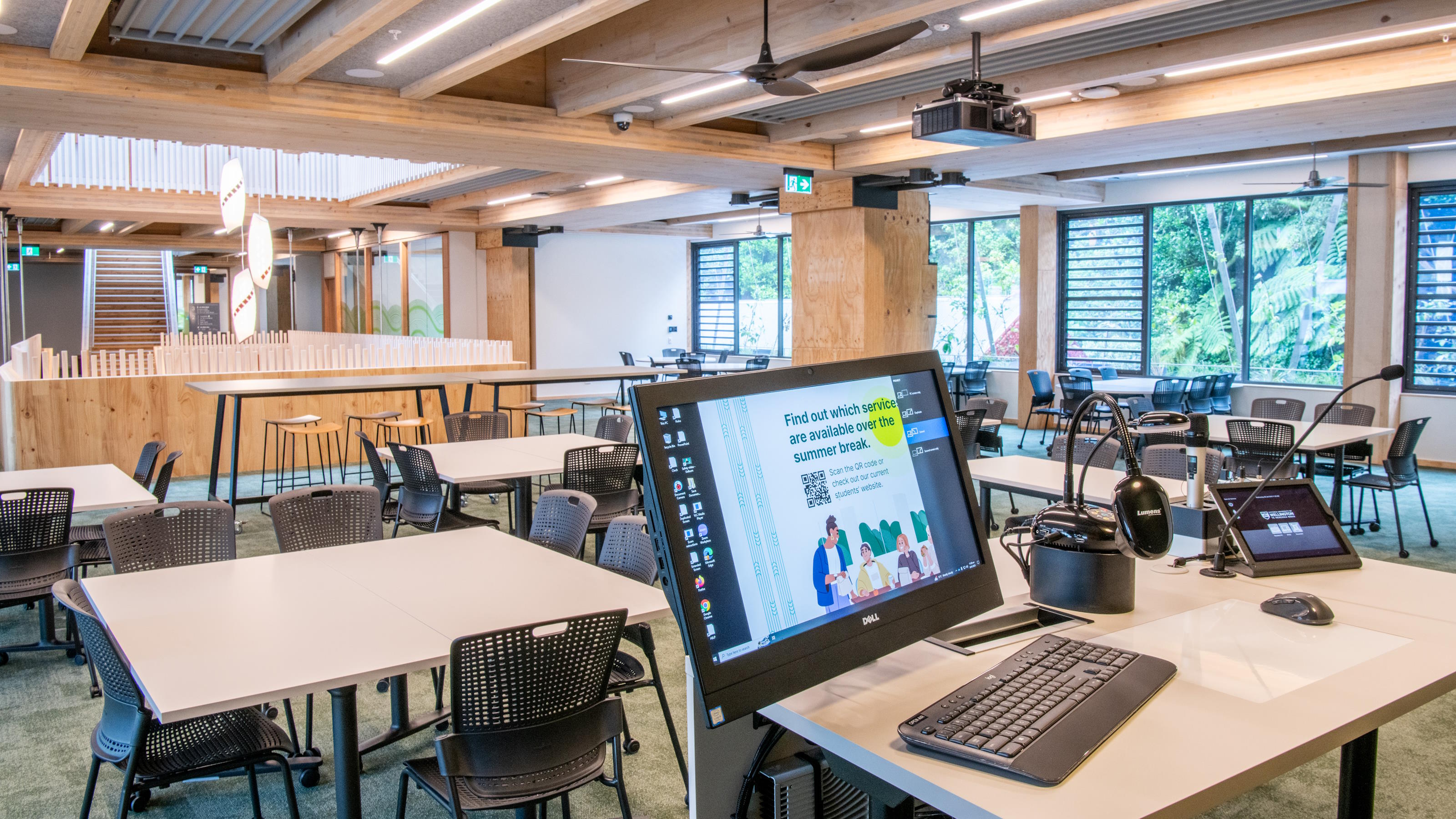 Room set up with chairs around tables, presenter's lecturn in foreground