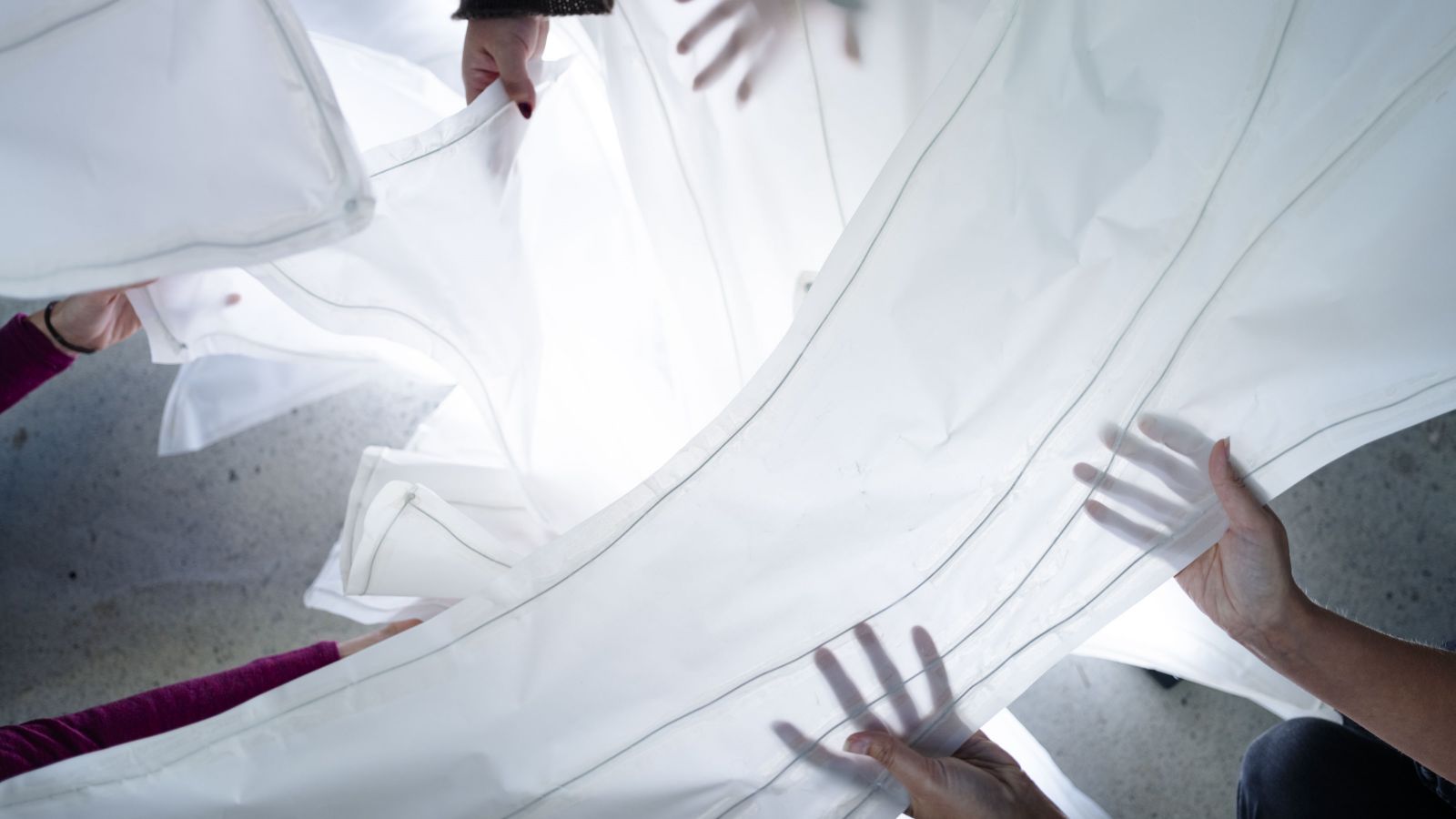 Hands holding translucent white panels 