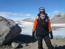Dr Rebecca Priestly standing in front of mountains in Taylor Valley, Antarctica