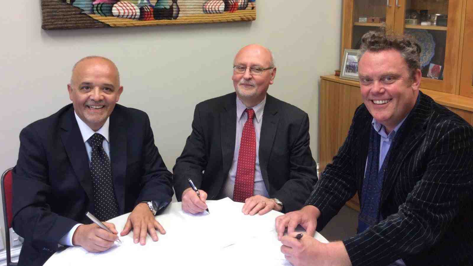 UVM’s Carlos Ramirez (left) signing the agreement with Victoria University Professors Roberto Rabel and Warwick Murray.