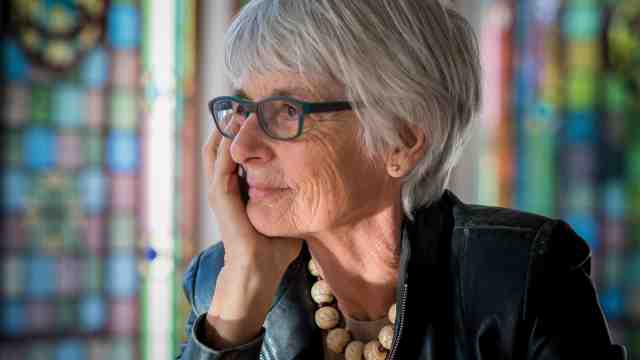 Emeritus Professor Lydia Wevers in front of stained glass windows