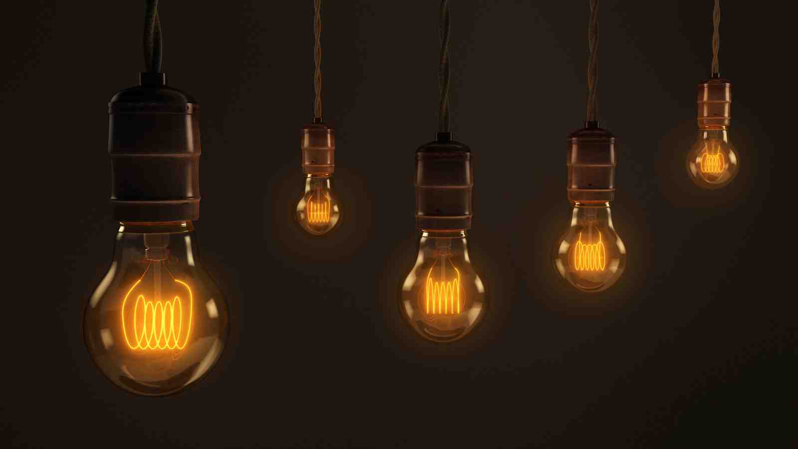 Five hanging light bulbs against a black background.