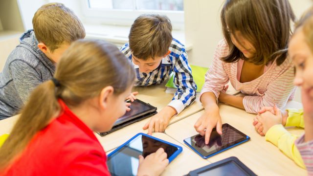 Kids learning with technology – children using tablets at a table.
