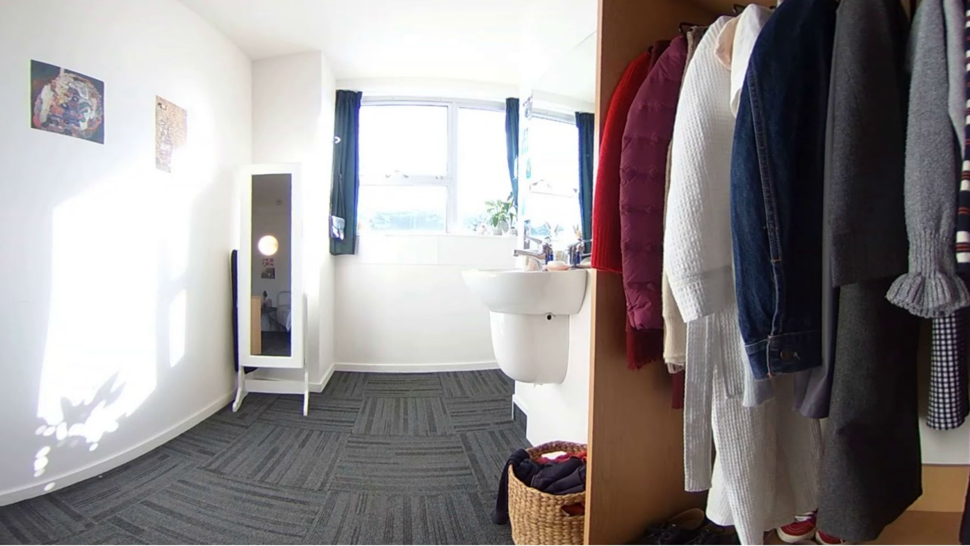 An image of a full wardrobe, a sink, and bright window.