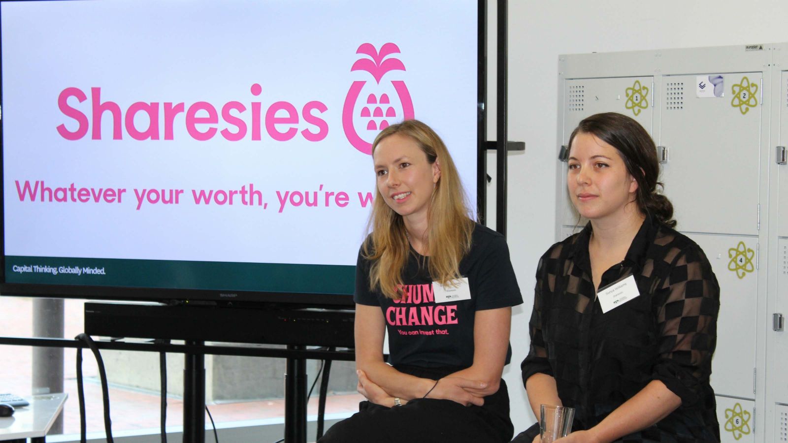 Brooke Roberts and Sonya Williams by a sign that says Sharesies.