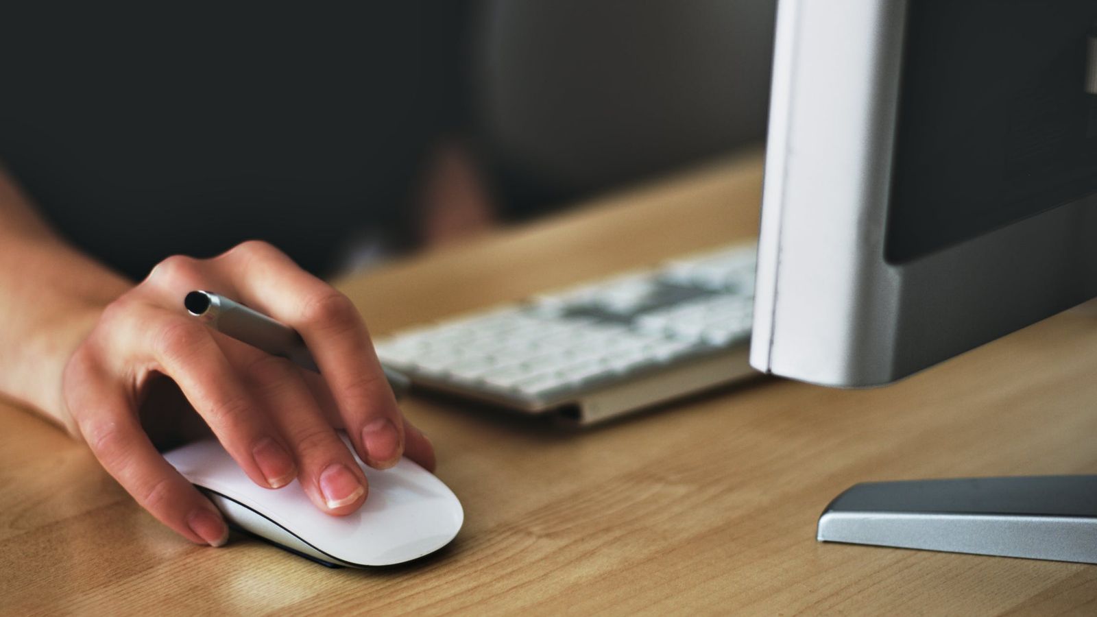 A student using a mouse by a computer.