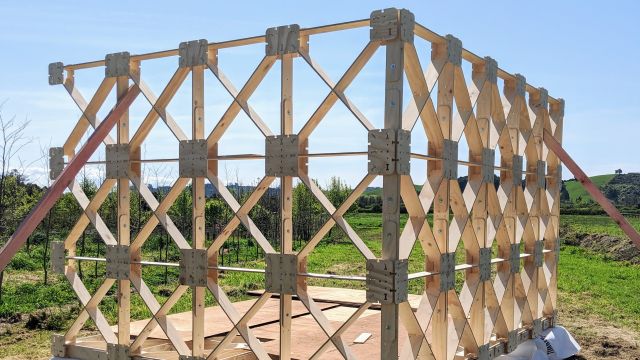 Ged Finch's xframe prototype being constructed. Two wooden panels of x shaped wood constructed in field