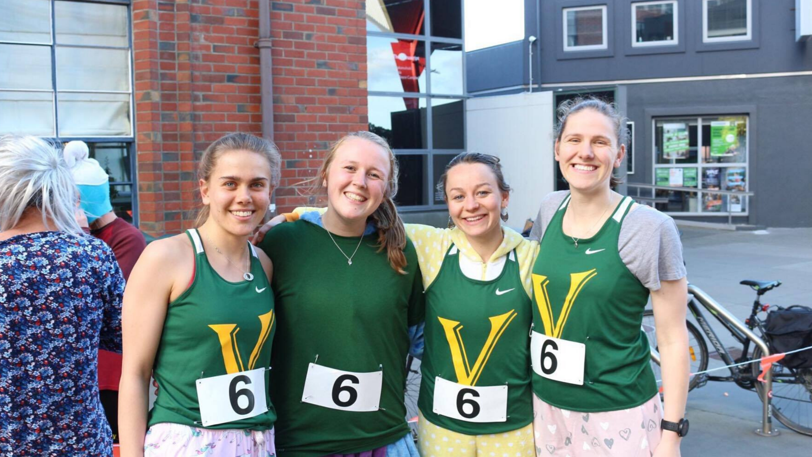 three girls grinning with Victoria running club singlets 
