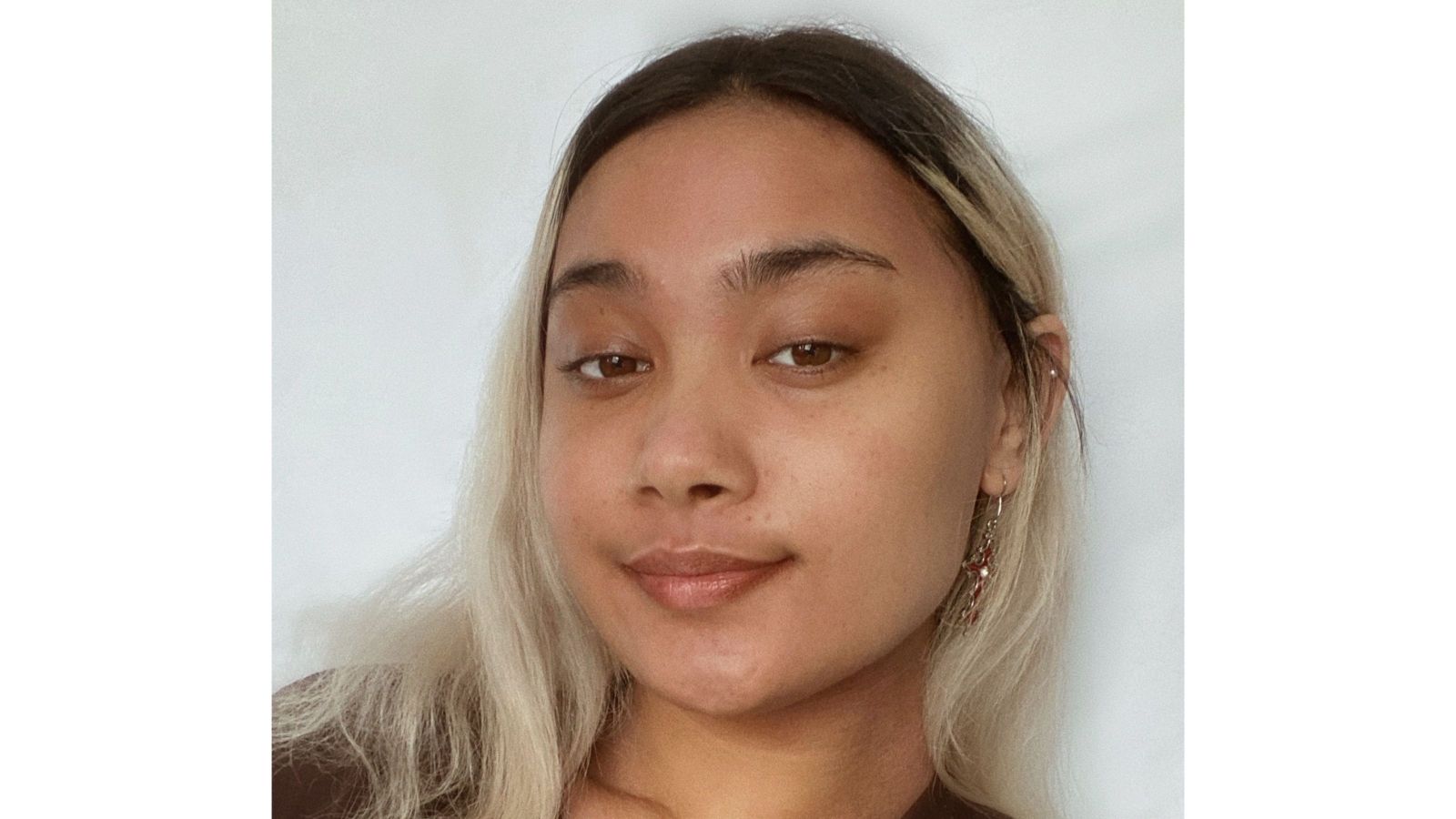 pasifika girl with dyed blond hair growing out, looking straight at camera