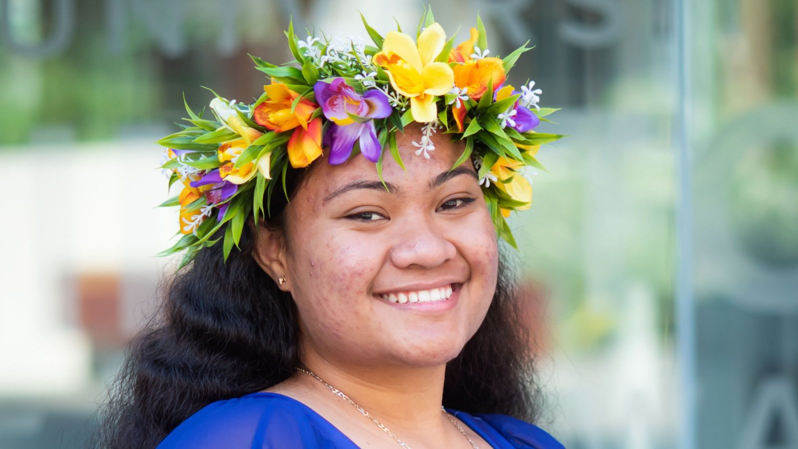Smiling girl with brown skin wearing flower headdress 