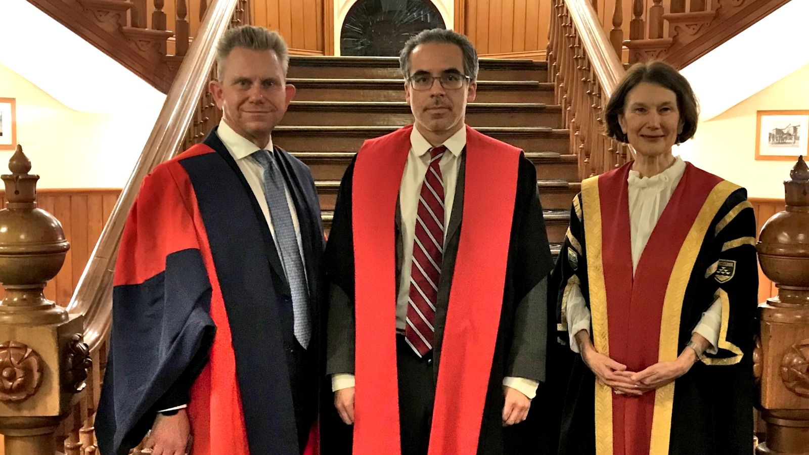 Three academics wearing formal gowns on the stairs of the Old Government building, from left to right Professor Mark Hickford, Professor Joel Colón-Ríos and Acting Vice-Chancellor Professor Jennifer Windsor.