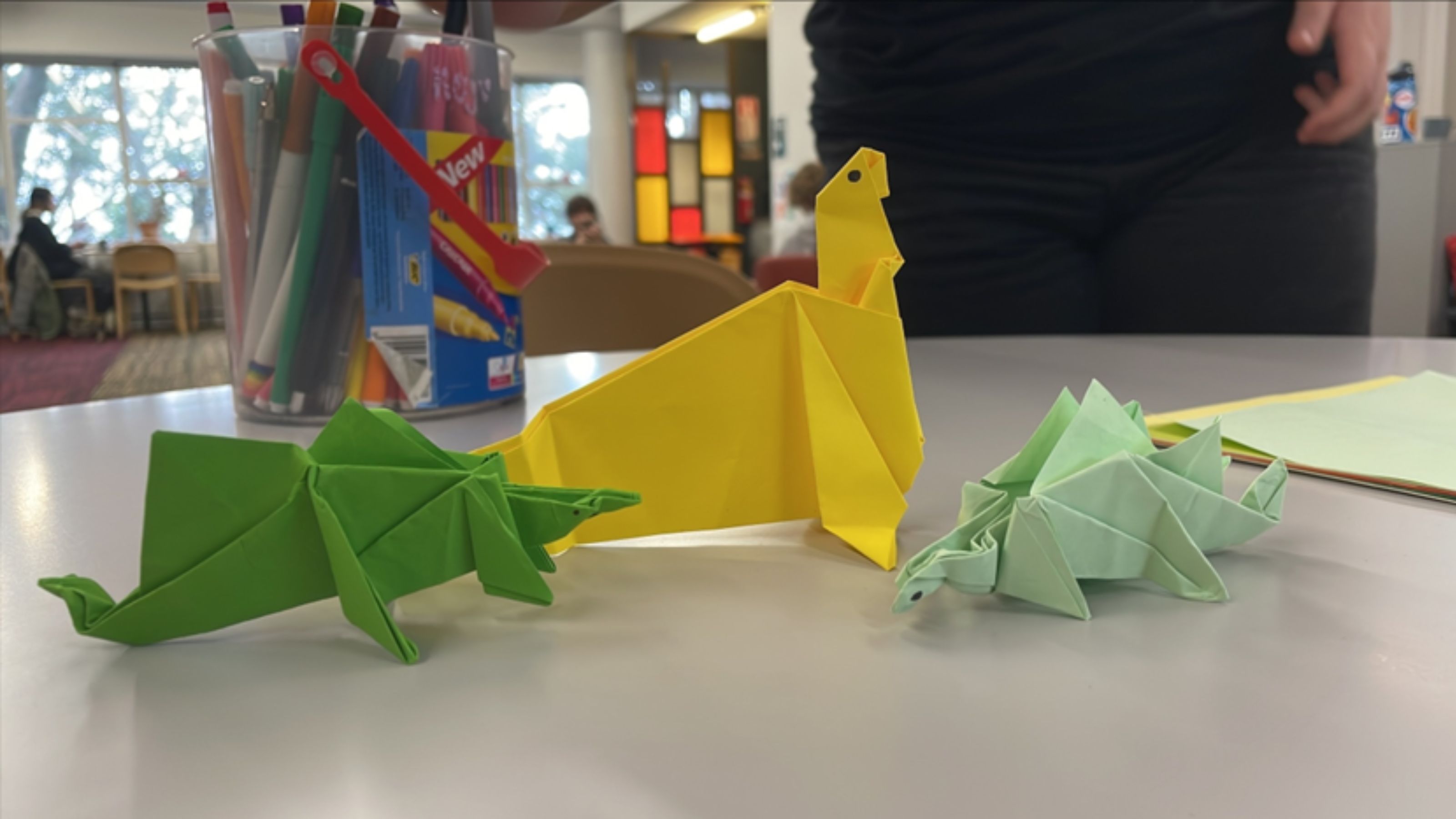 Origami dinosaurs resting on a table in The Bubble at Kelburn campus