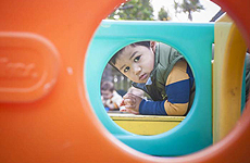 A boy playing on a jungle gym.