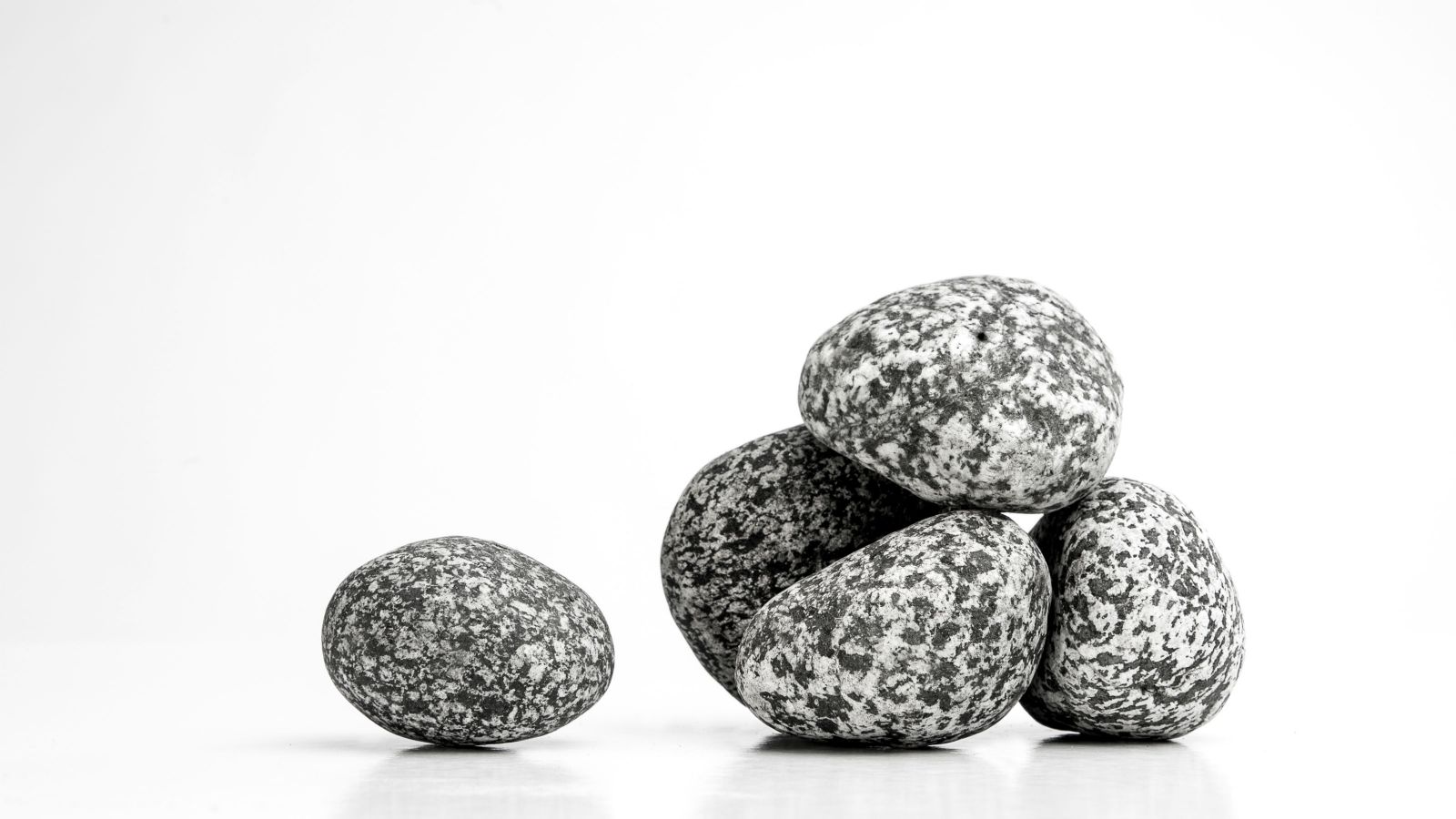 A small pile of grey stones against a white background.