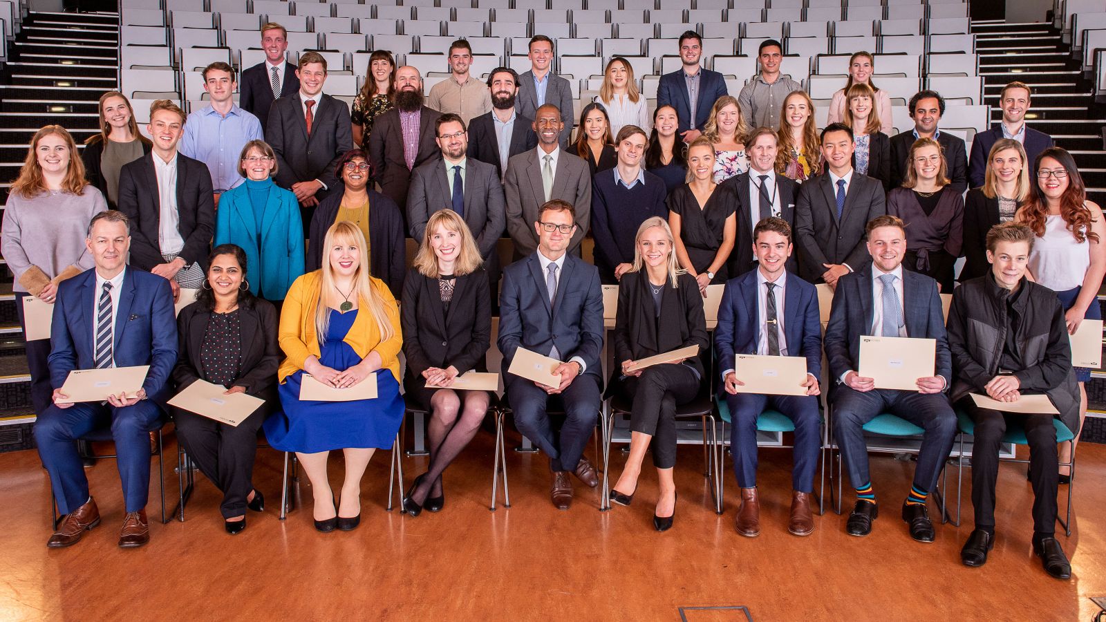Victoria Business School celebrates – a group poses in a lecture hall.