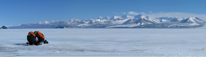 Taking samples in Antarctica with Royal Society Range in the background.