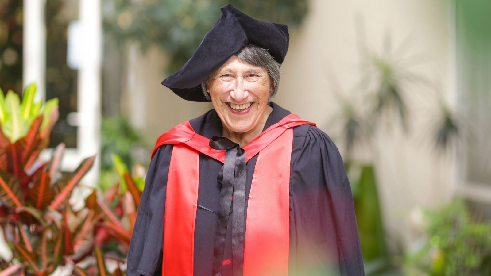 Kura Taylor smiling, wearing graduation robes