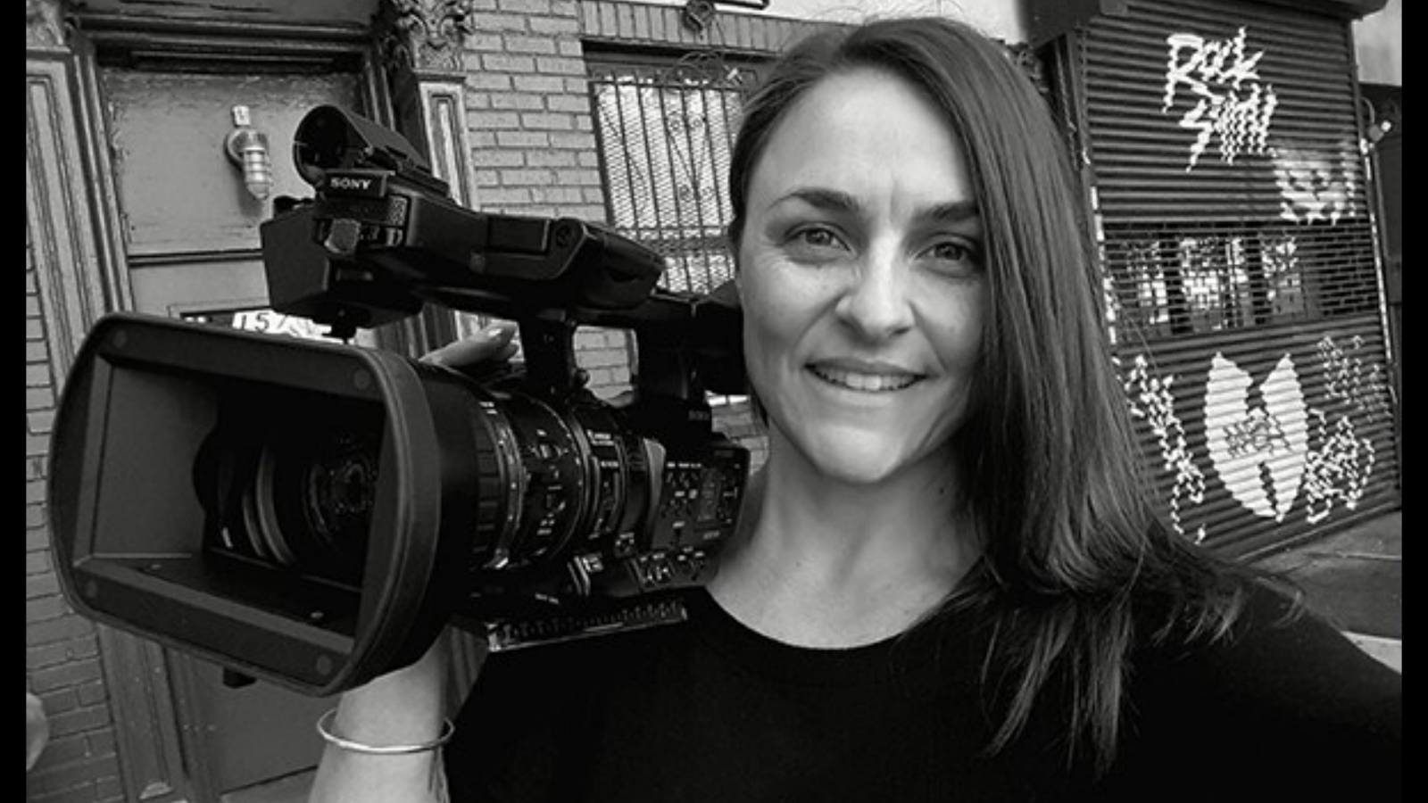 Māori woman with a video camera in black and white image city background 