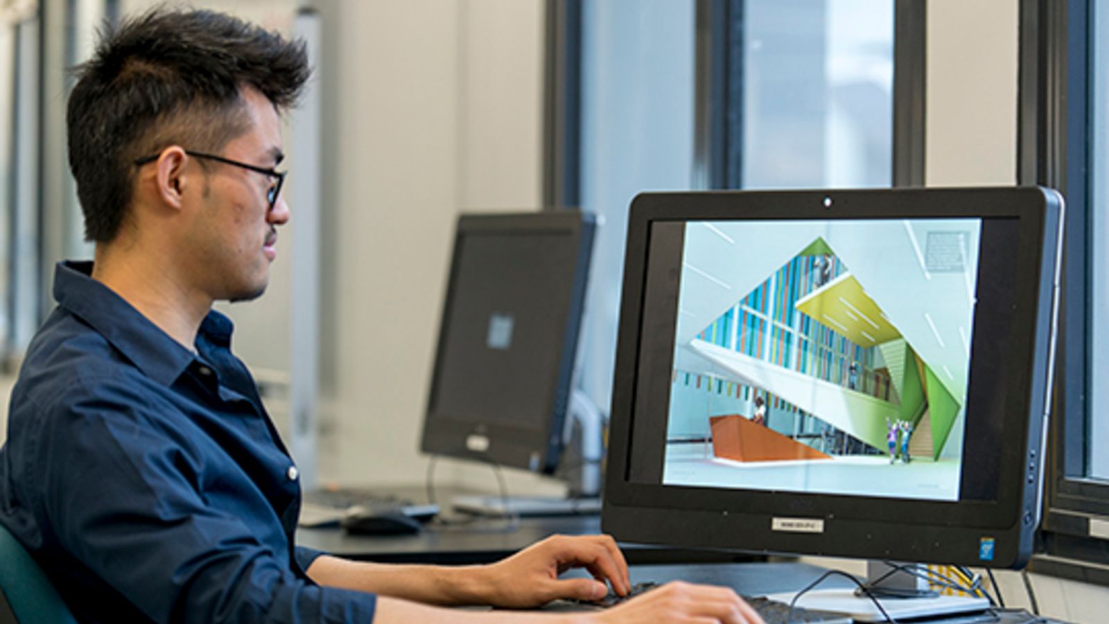 Xi Shao sat at desk looking at computer.