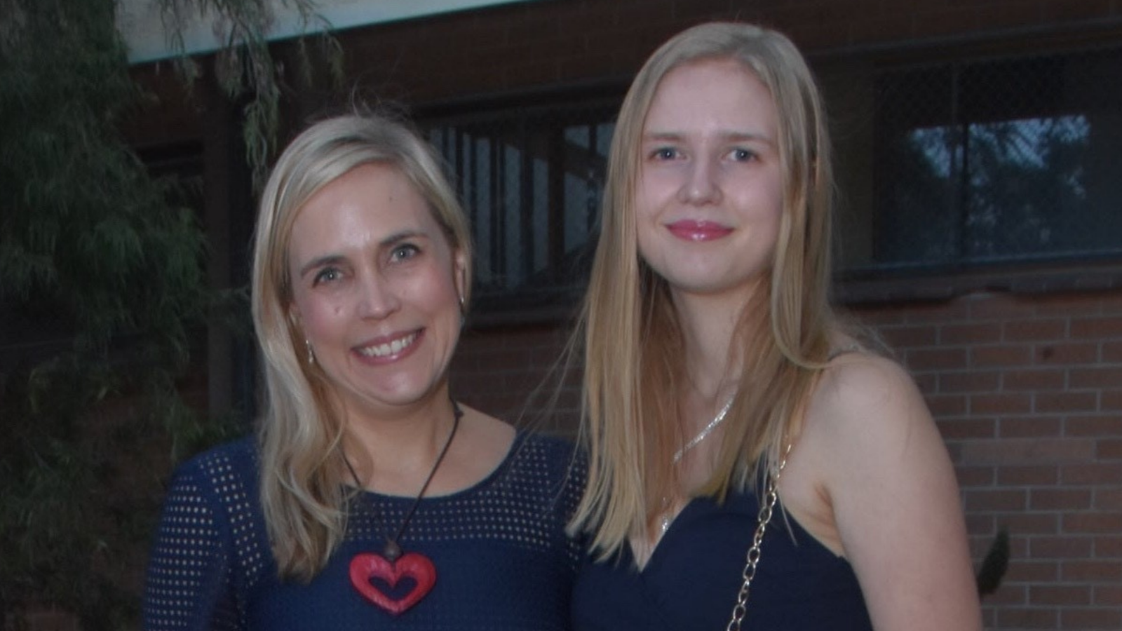 two blonde women who look similar with formal clothes on